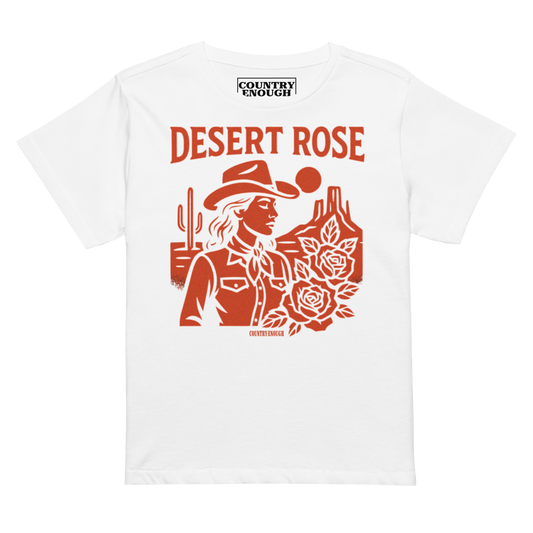 White t-shirt with graphic of cowgirl, desert landscape, roses, and words desert rose #white