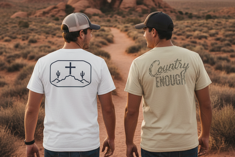 Two men in casual short sleeve t-shirts and caps, walking on a desert path.