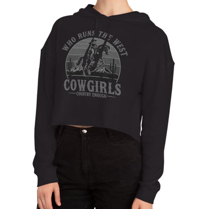 Black crop hoodie with graphic of a cowgirls on a bucking horse, cacti, mountains, and the words who runs the west cowgirls #black