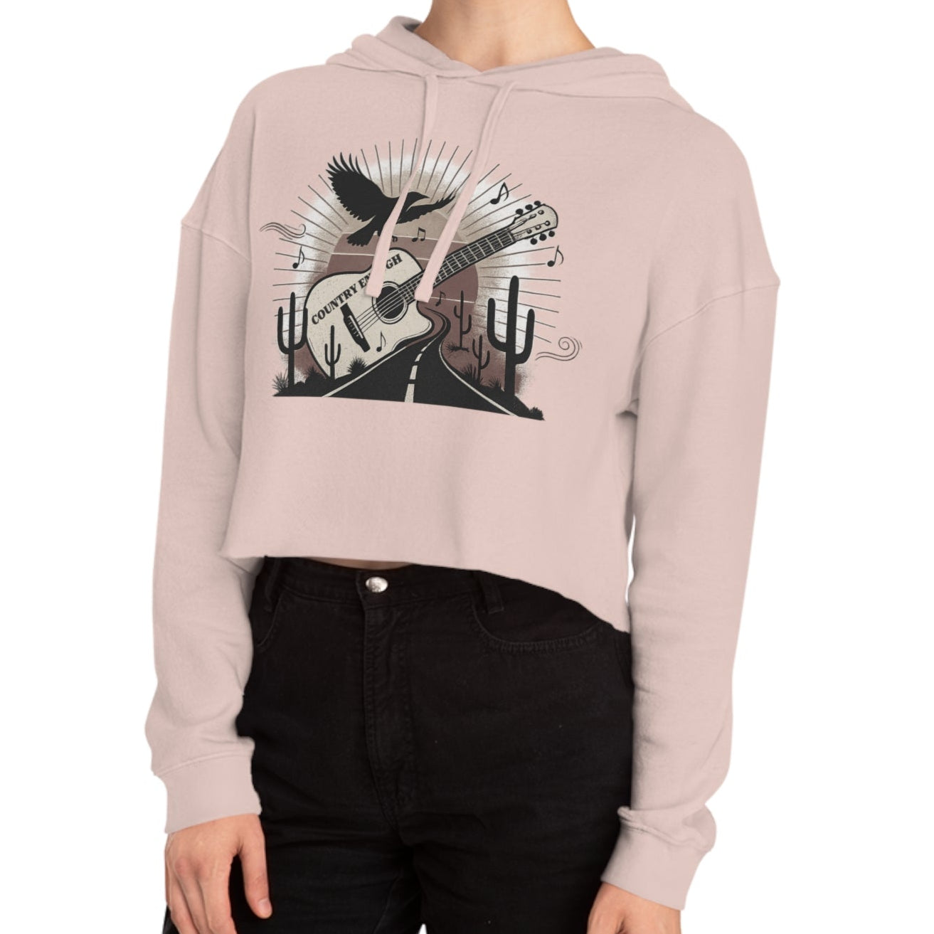 Pale Pink crop hoodie with a graphic of a guitar, a soaring desert bird, cactus silhouettes, and a sunset over a winding road #palepink
