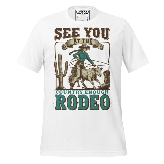 White t-shirt with graphic of cowgirl, calf, cactus, cowboy boot, and words see you at the rodeo #white