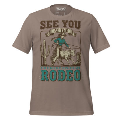 Pebble t-shirt with graphic of cowgirl, calf, cactus, cowboy boot, and words see you at the rodeo #pebble