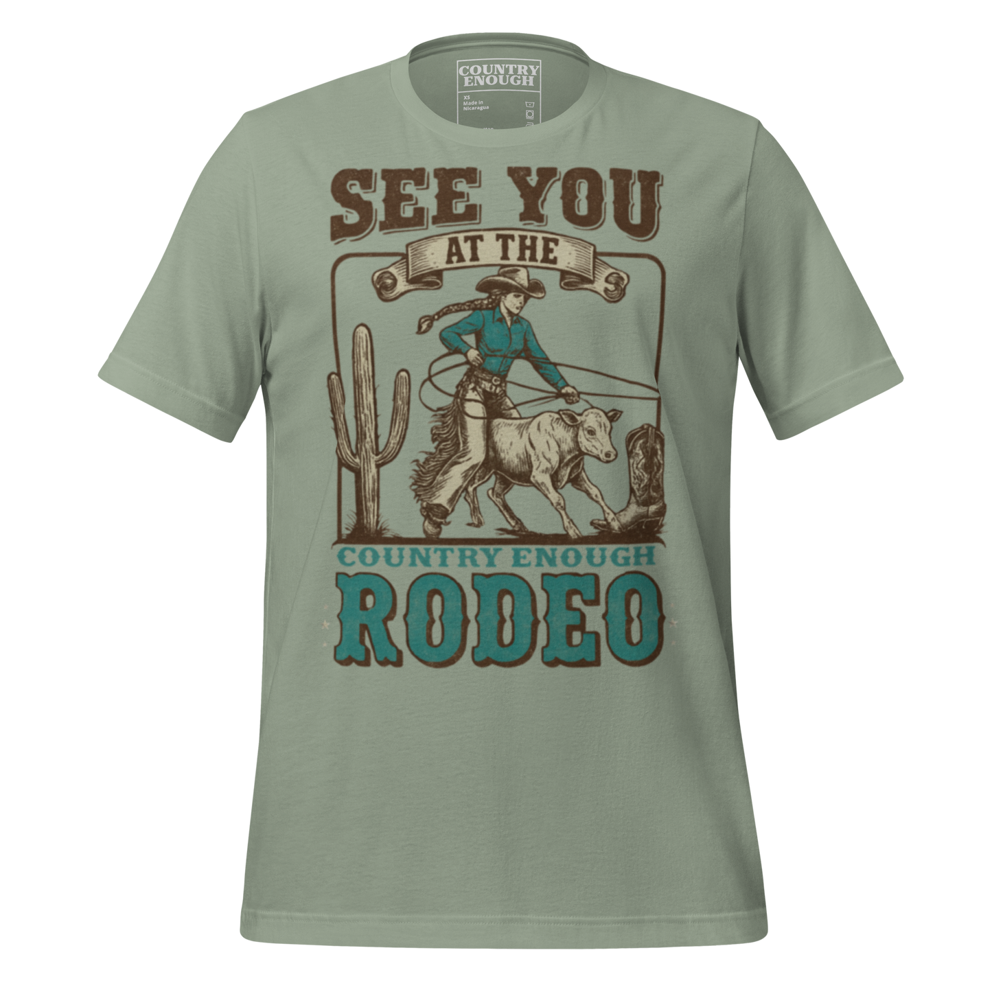 Sage t-shirt with graphic of cowgirl, calf, cactus, cowboy boot, and words see you at the rodeo #sage