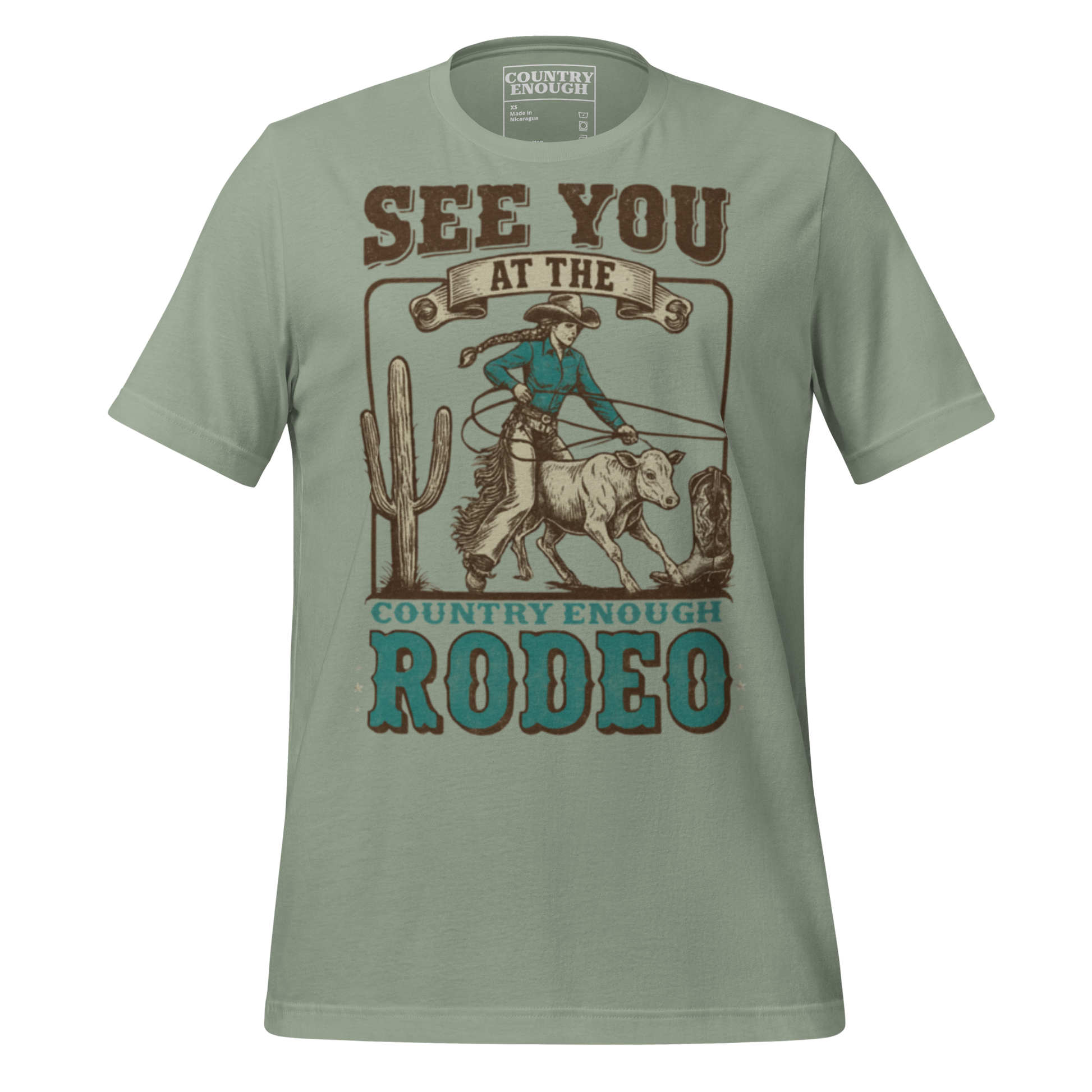 Sage t-shirt with graphic of cowgirl, calf, cactus, cowboy boot, and words see you at the rodeo #sage
