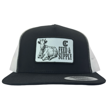 Yupoong 6006 snapback hat with patch that contains graphic of a sitting cow, the words Feed & Supply, and the CE logo. #black/white