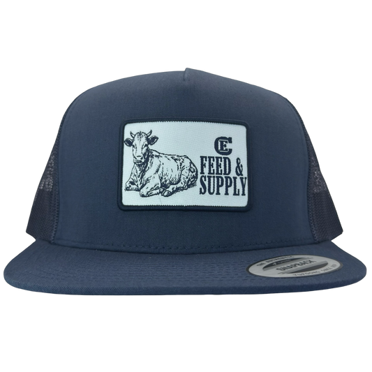 Yupoong 6006 snapback hat with patch that contains graphic of a sitting cow, the words Feed & Supply, and the CE logo. #navy