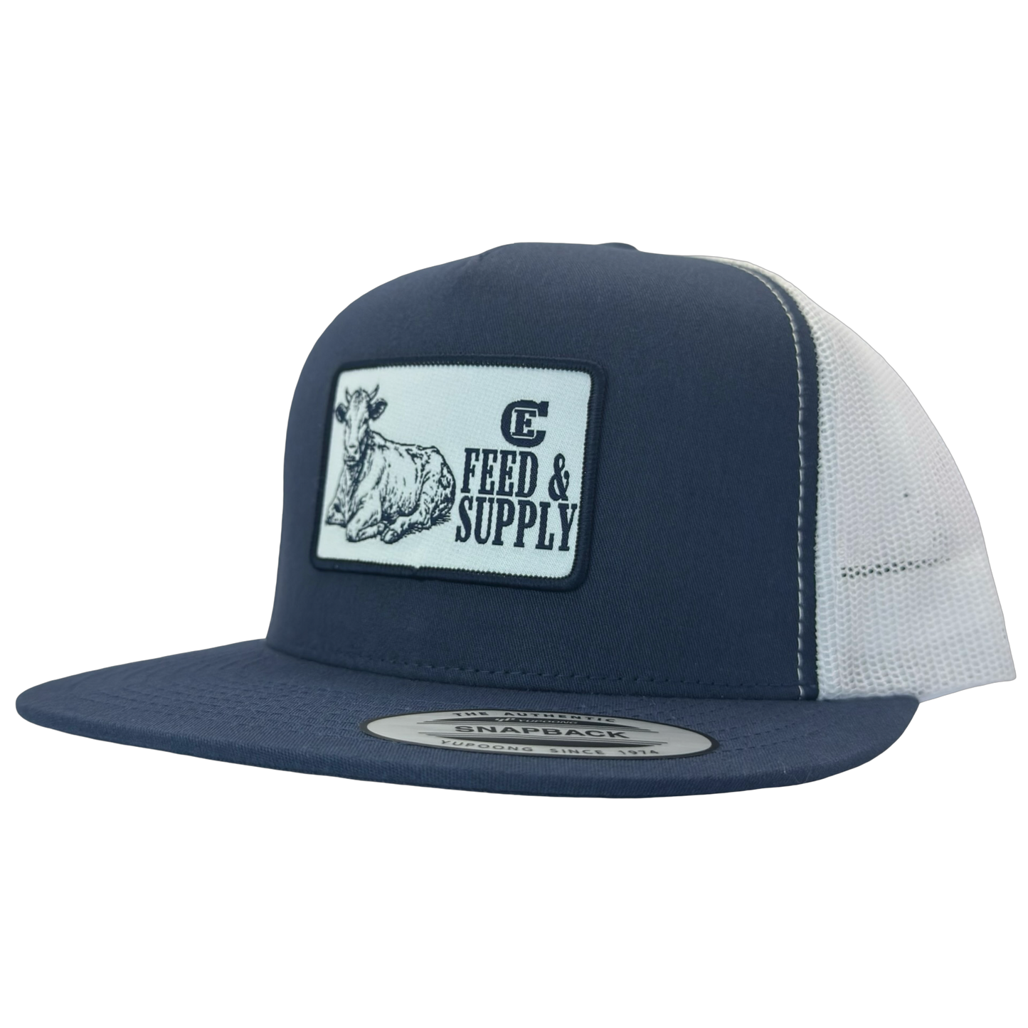 Yupoong 6006 snapback hat with patch that contains graphic of a sitting cow, the words Feed & Supply, and the CE logo. #navy/white