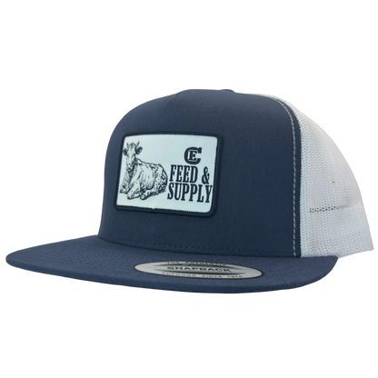 Yupoong 6006 snapback hat with patch that contains graphic of a sitting cow, the words Feed & Supply, and the CE logo. #navy/white