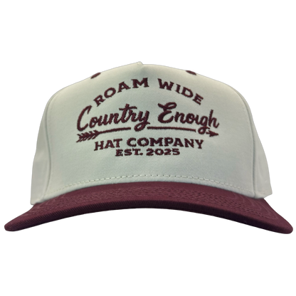 legacy heritage snapback with graphic of arrow and words roam wide, country enough hat company est. 2025 #wine
