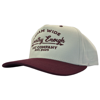 legacy heritage snapback with graphic of arrow and words roam wide, country enough hat company est. 2025 #wine