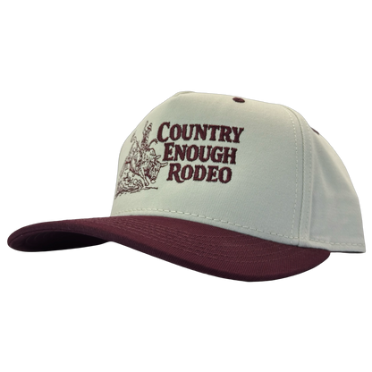Legacy heritage snapback hat with graphic of bull rider on a bucking bull and the words country enough rodeo #wine