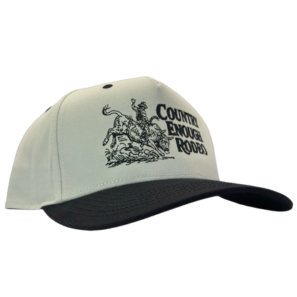 Legacy heritage snapback hat with graphic of bull rider on a bucking bull and the words country enough rodeo #black