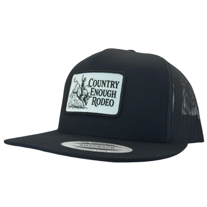 Yupoong 6006 flat bill snapback with a patch that contains graphic of a bullrider and bucking bull and words country enough rodeo #black