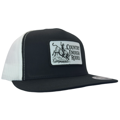 Yupoong 6006 flat bill snapback with a patch that contains graphic of a bullrider and bucking bull and words country enough rodeo #black/white