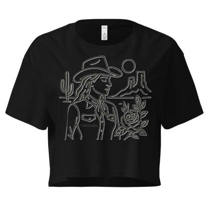Black crop top with graphic of a cowgirl, desert landscape, sun, cacti, and rose #black