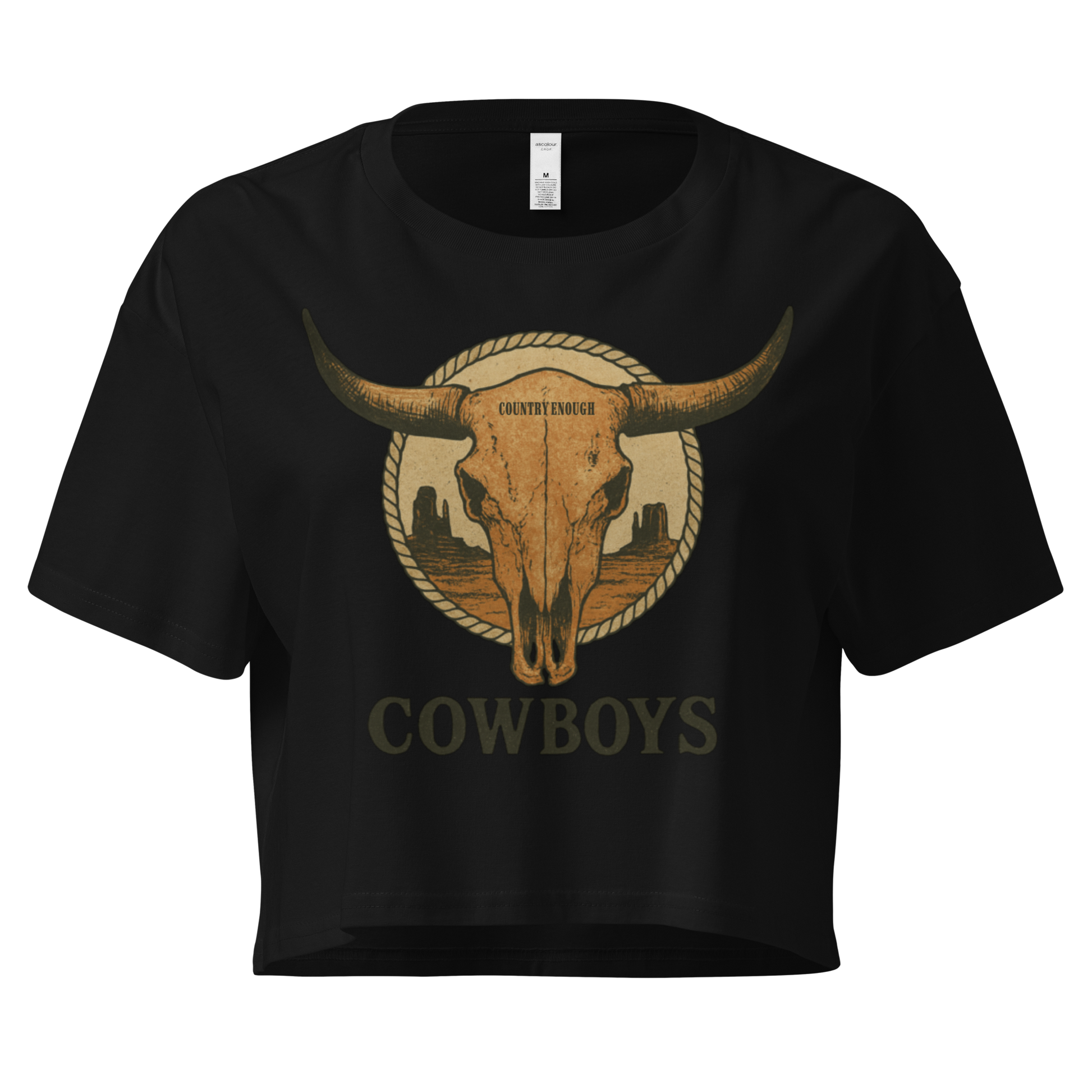 Black crop top with graphic of bull skull in front of a circular desert landscape with rope border and word cowboy below #black