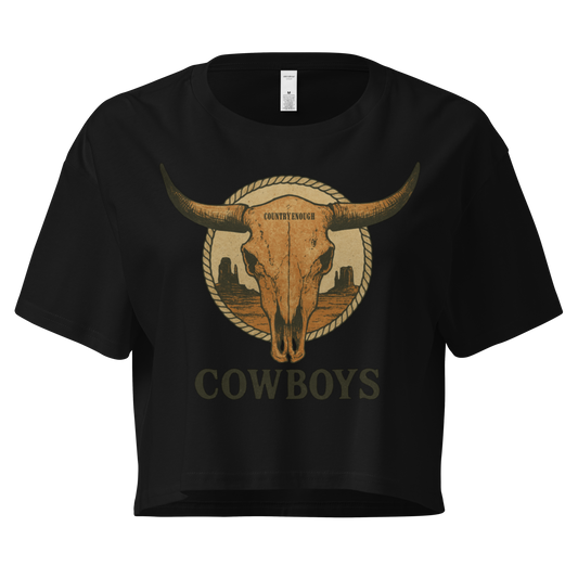 Black crop top with graphic of bull skull in front of a circular desert landscape with rope border and word cowboy below #black
