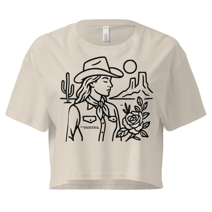 Bone crop top with graphic of a cowgirl, desert landscape, sun, cacti, and rose #bone