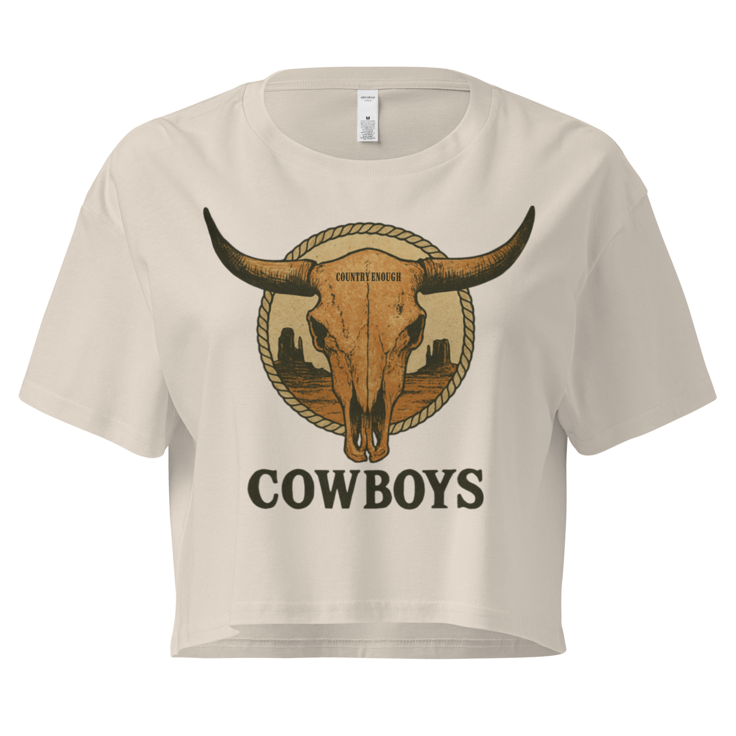 Bone crop top with graphic of bull skull in front of a circular desert landscape with rope border and word cowboy below #bone
