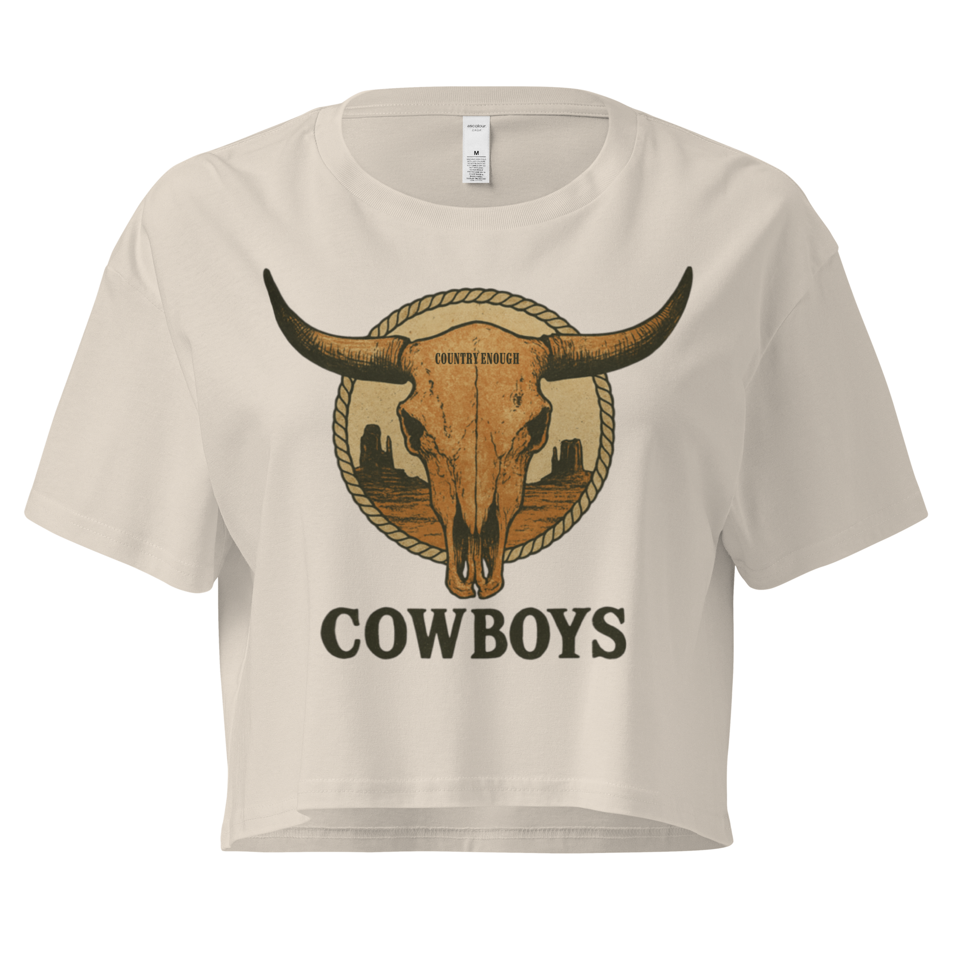 Bone crop top with graphic of bull skull in front of a circular desert landscape with rope border and word cowboy below #bone