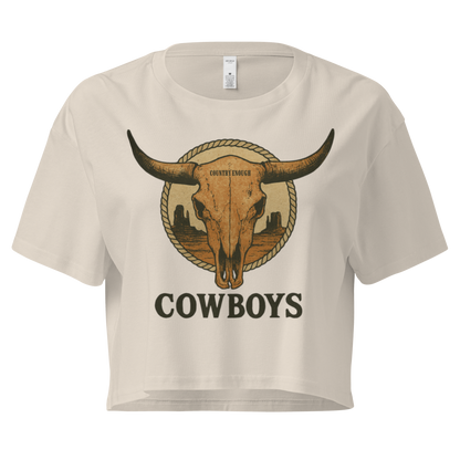 Bone crop top with graphic of bull skull in front of a circular desert landscape with rope border and word cowboy below #bone