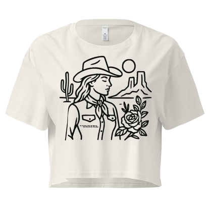 Ecru crop top with graphic of a cowgirl, desert landscape, sun, cacti, and rose #ecru