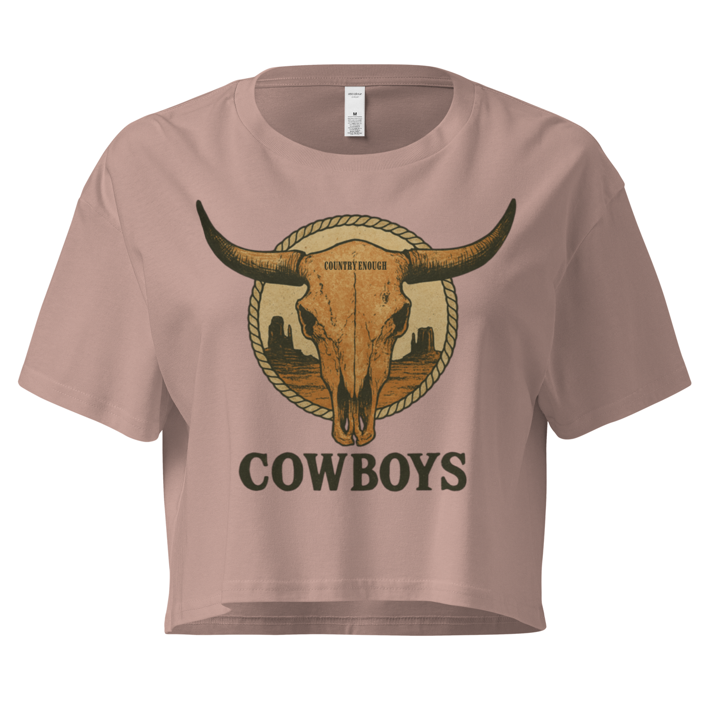 Hazy Pink crop top with graphic of bull skull in front of a circular desert landscape with rope border and word cowboy below #hazypink
