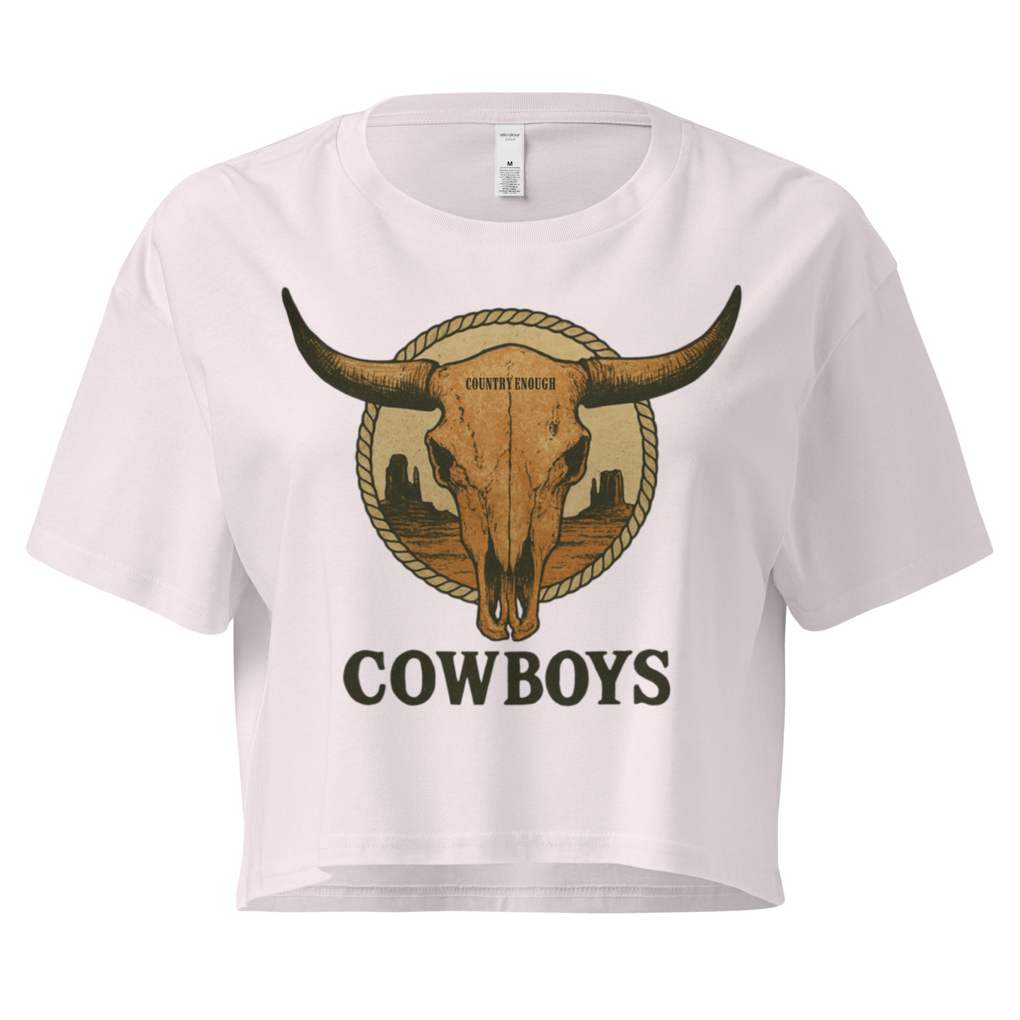 Orchid crop top with graphic of bull skull in front of a circular desert landscape with rope border and word cowboy below #orchid