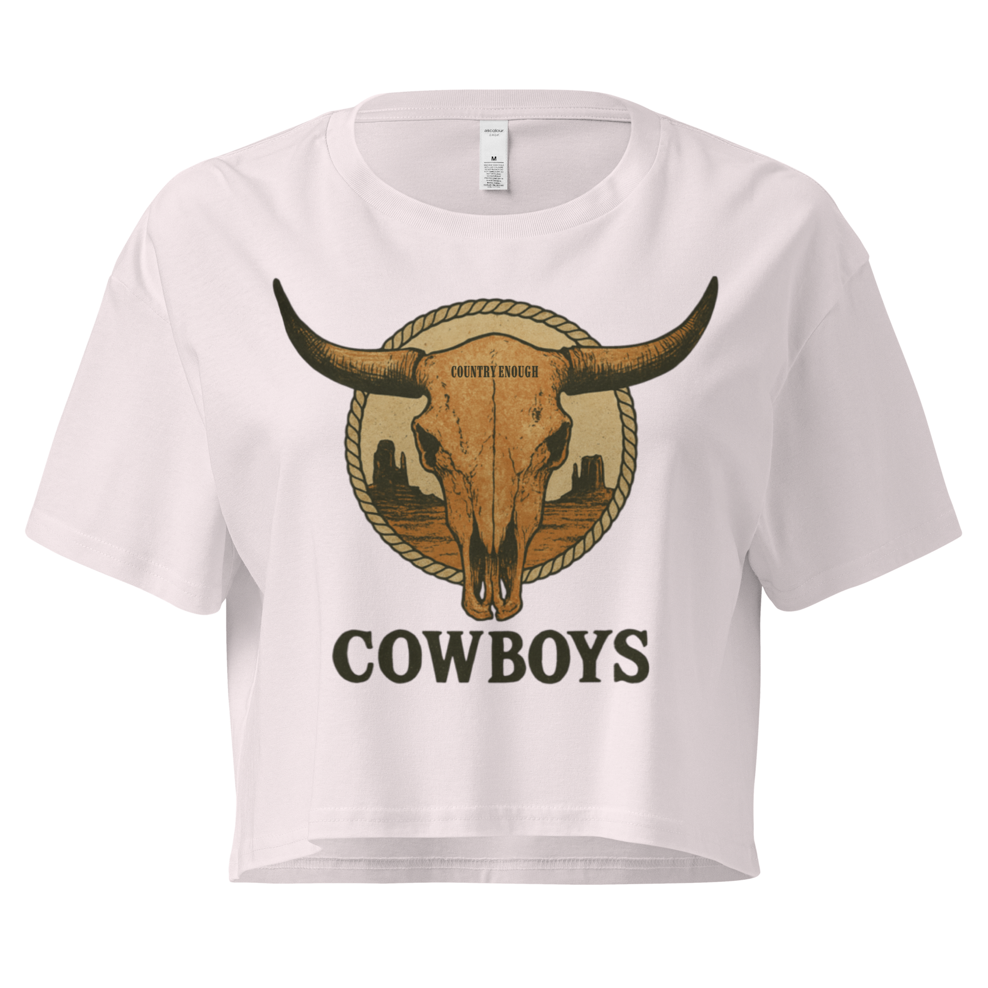 Orchid crop top with graphic of bull skull in front of a circular desert landscape with rope border and word cowboy below #orchid
