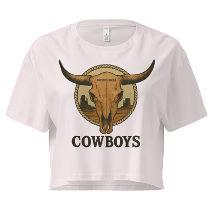 Orchid crop top with graphic of bull skull in front of a circular desert landscape with rope border and word cowboy below #orchid