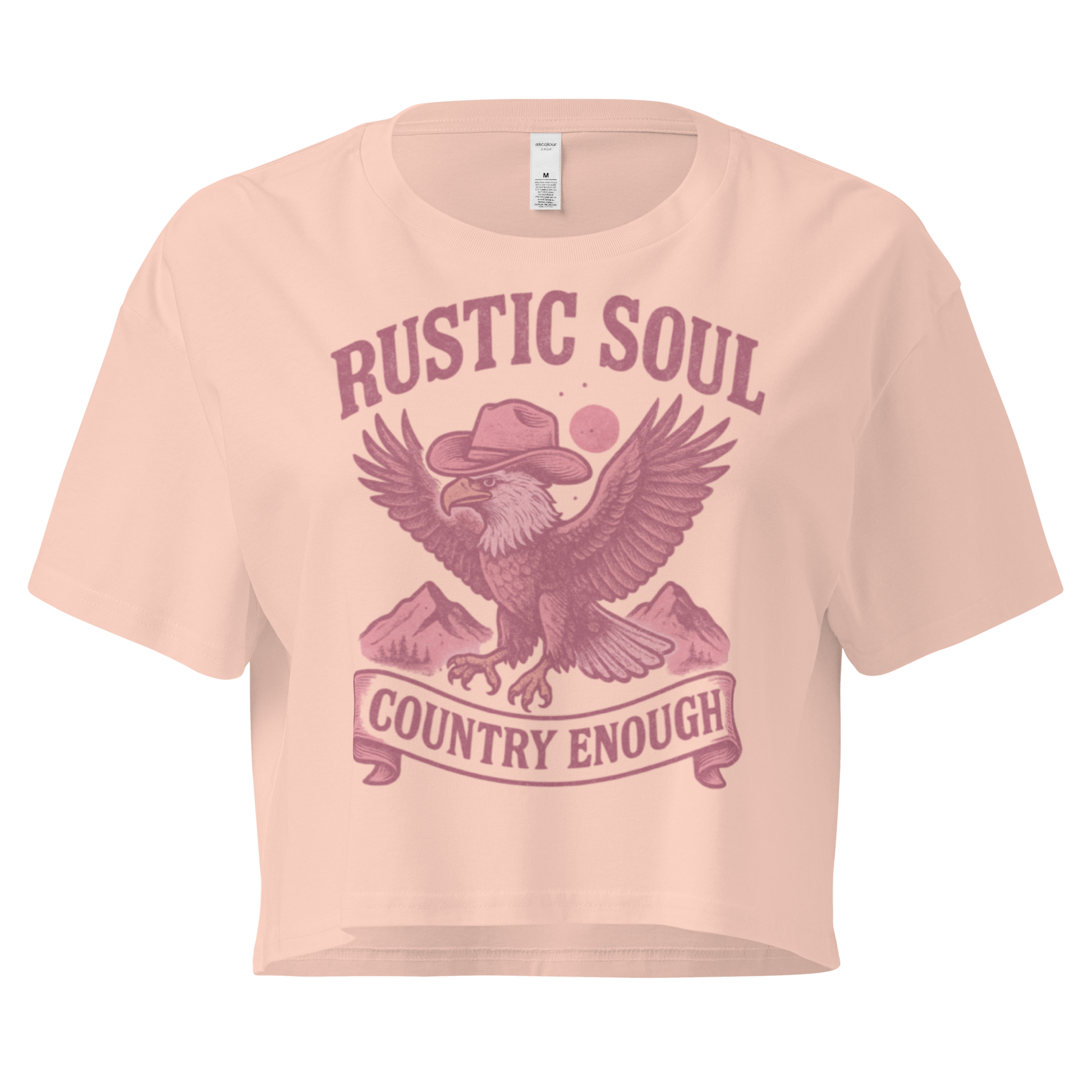 Pale Pink crop top with graphic of cowboy hat wearing eagle, mountains, and words rustic soul and country enough #palepink