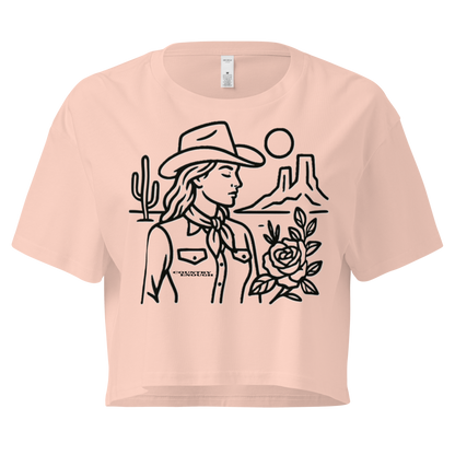Pale Pink crop top with graphic of a cowgirl, desert landscape, sun, cacti, and rose #palepink