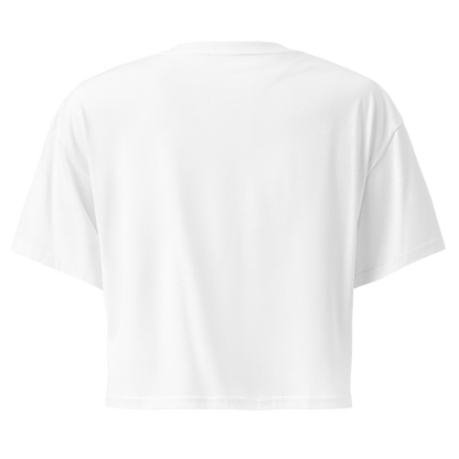 White crop top with graphic of bull skull in front of a circular desert landscape with rope border and word cowboy below #white