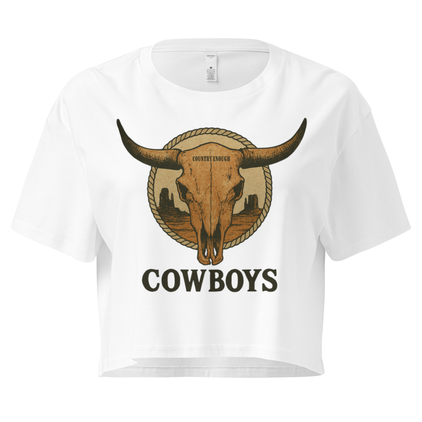 White crop top with graphic of bull skull in front of a circular desert landscape with rope border and word cowboy below #white