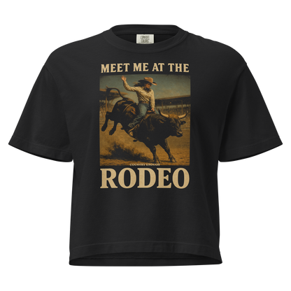 Black t-shirt with graphic of cowgirl riding a bucking bull and the words meet me at the rodeo #black
