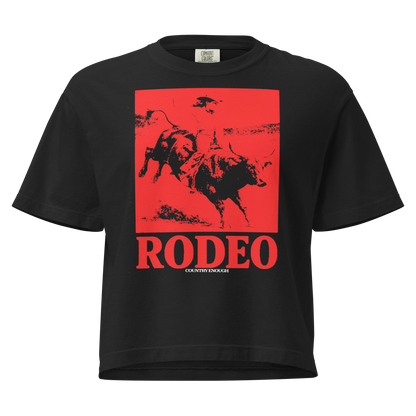 Black t-shirt with bright red graphic of a cowgirl riding a bull and the word rodeo below #black