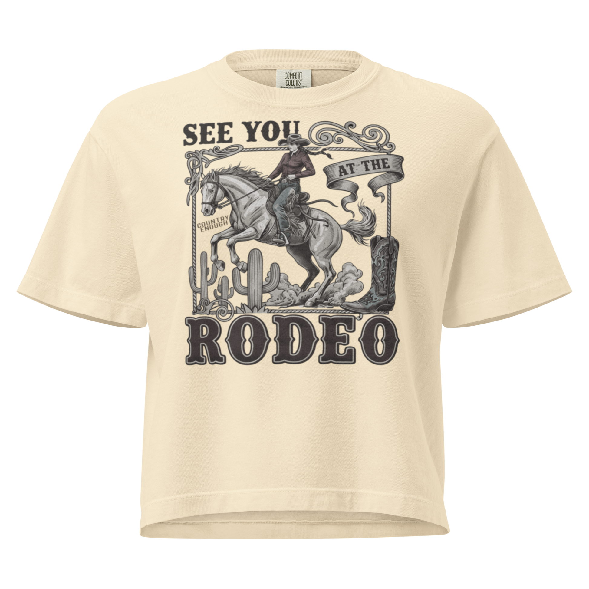 Ivory t-shirt with graphic of cowgirl, cowboy boot, cacti, horse, and words see you at the rodeo #ivory