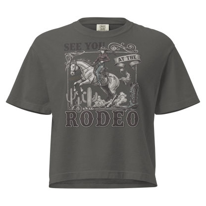 Gray t-shirt with graphic of cowgirl, cowboy boot, cacti, horse, and words see you at the rodeo #gray