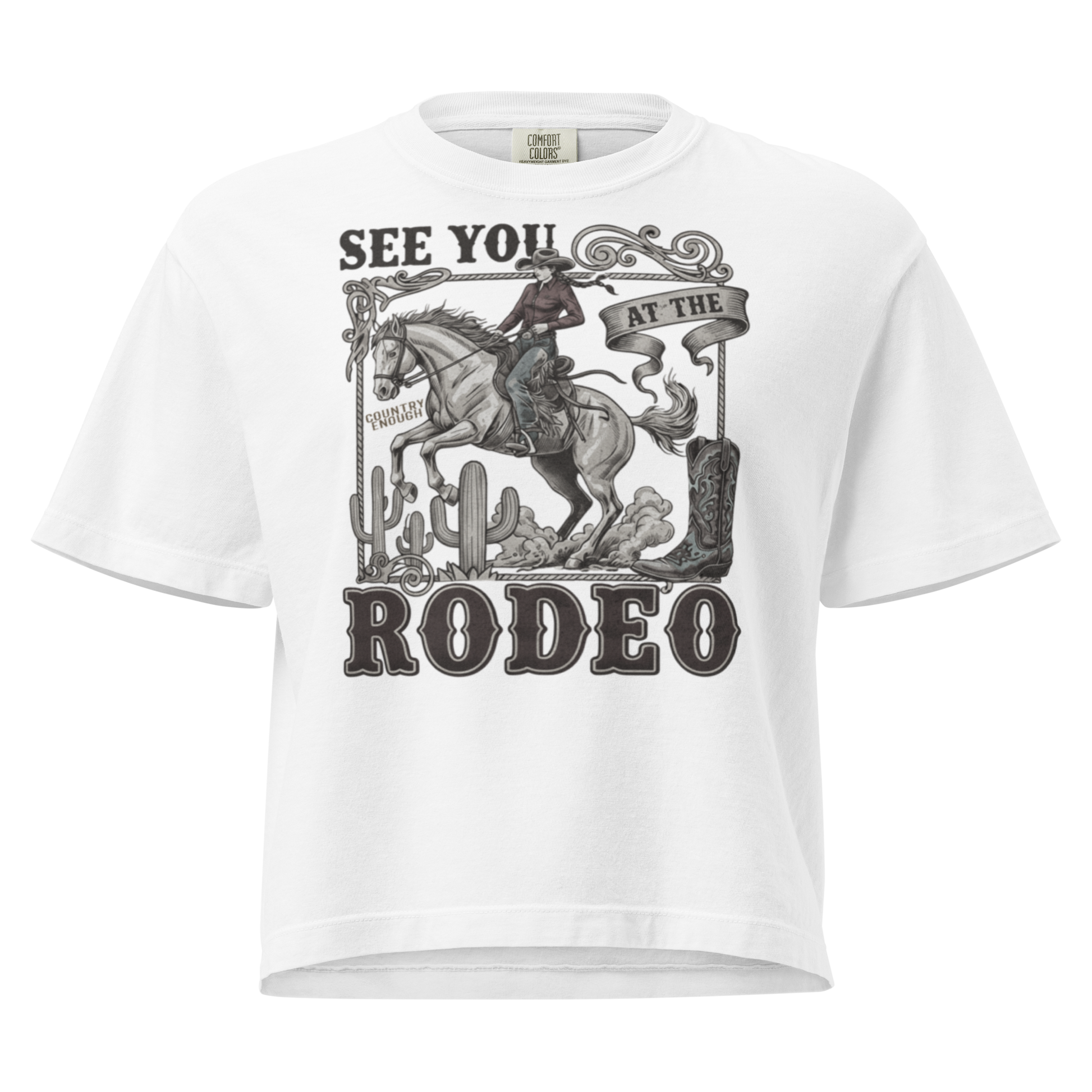 White t-shirt with graphic of cowgirl, cowboy boot, cacti, horse, and words see you at the rodeo #white