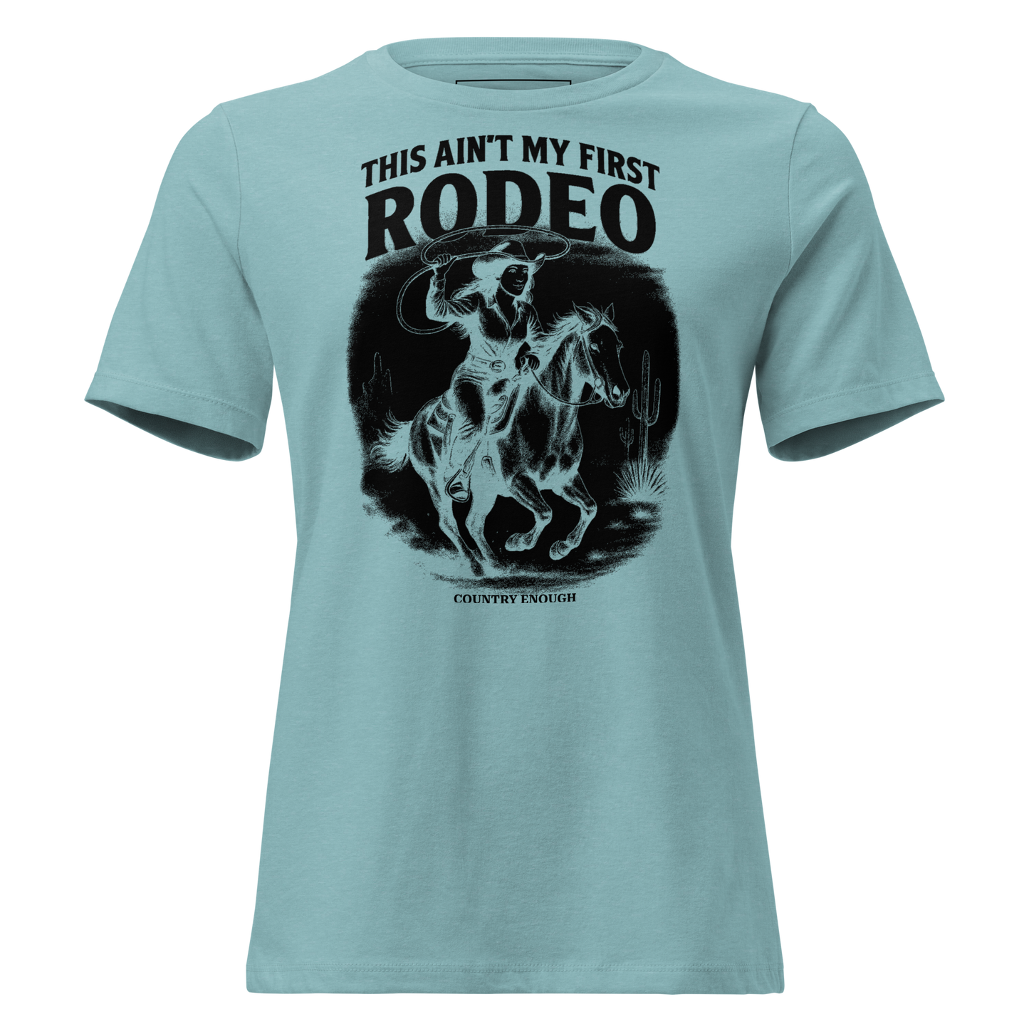 Heather Blue Lagoon t-shirt with graphic of a cowgirl on a horse, lassoing, in front of a desert landscape with words this ain't my first rodeo above #heatherbluelagoon
