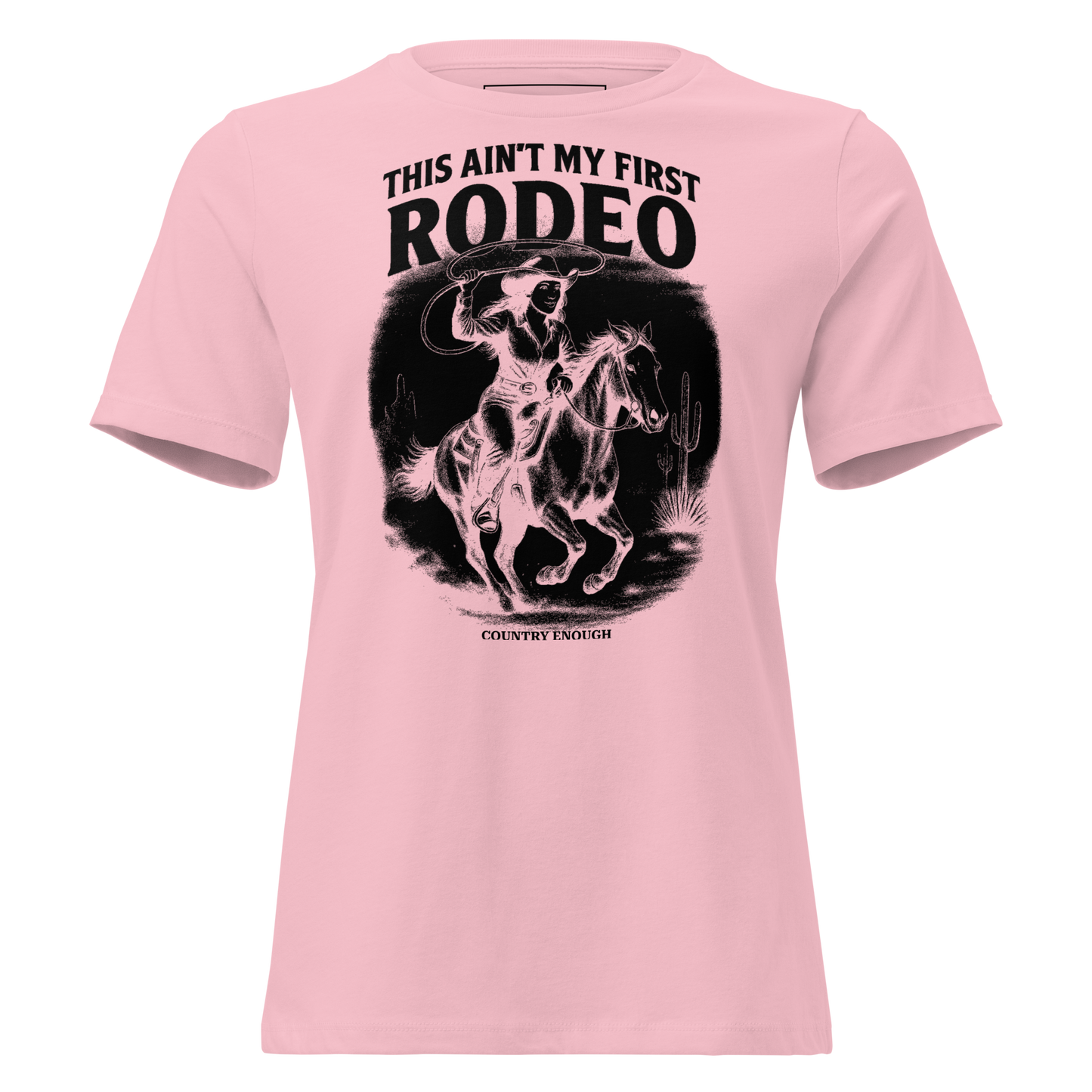 Pink t-shirt with graphic of a cowgirl on a horse, lassoing, in front of a desert landscape with words this ain't my first rodeo above #pink