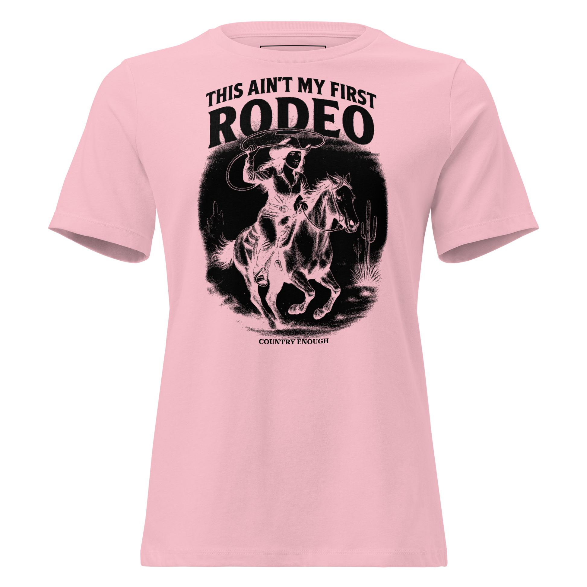 Pink t-shirt with graphic of a cowgirl on a horse, lassoing, in front of a desert landscape with words this ain't my first rodeo above #pink