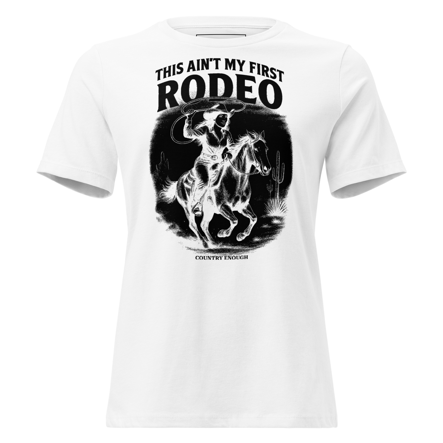 White t-shirt with graphic of a cowgirl on a horse, lassoing, in front of a desert landscape with words this ain't my first rodeo above #white