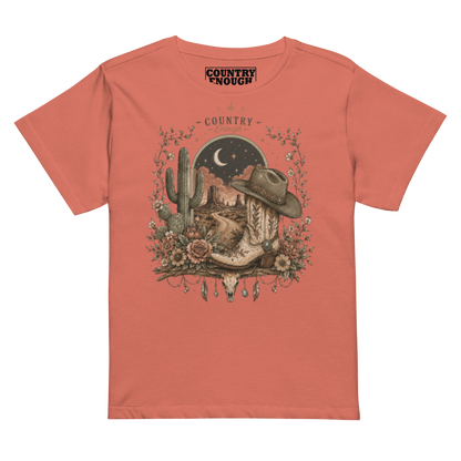 Women's t-shirt with graphic of bull skull, cowboy boot, cowboy hat, desert landscape and night sky. #redsorbet