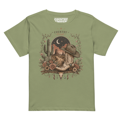 Women's t-shirt with graphic of bull skull, cowboy boot, cowboy hat, desert landscape and night sky. #artichoke