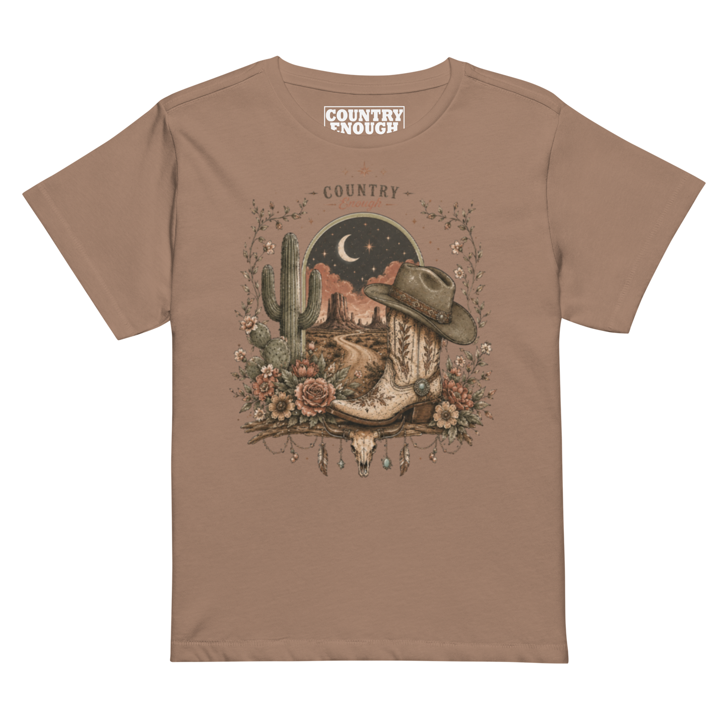 Women's t-shirt with graphic of bull skull, cowboy boot, cowboy hat, desert landscape and night sky. #latte