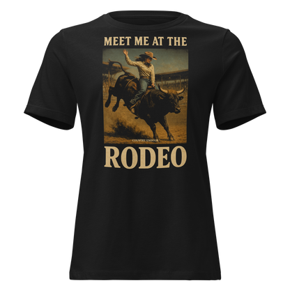 Black t-shirt with graphic of cowgirl riding a bucking bull and the words meet me at the rodeo #black